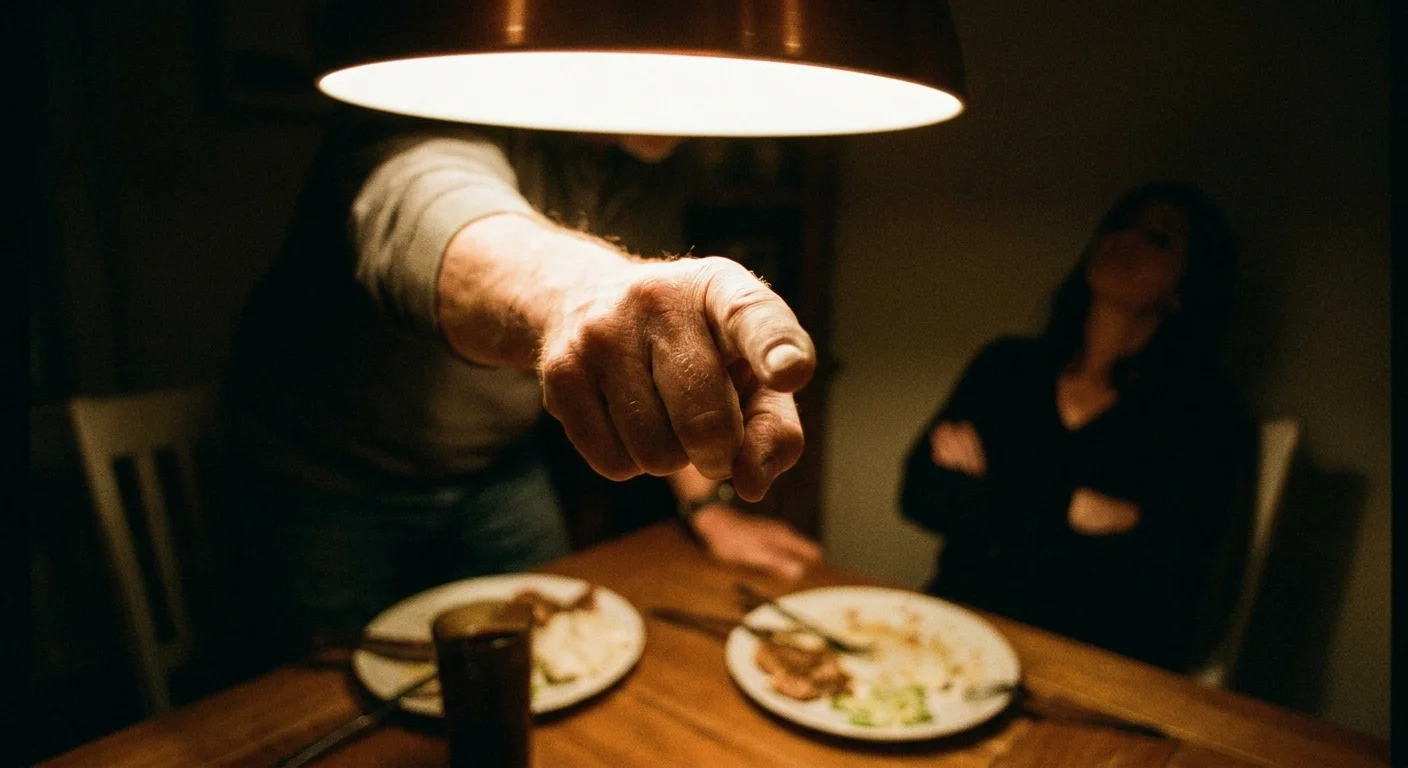 Close-up of a man's hand pointing aggressively during a conversation at a dinner table.